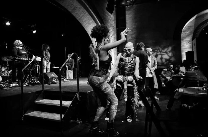 Black and white photo of two dancers performing beside the stage